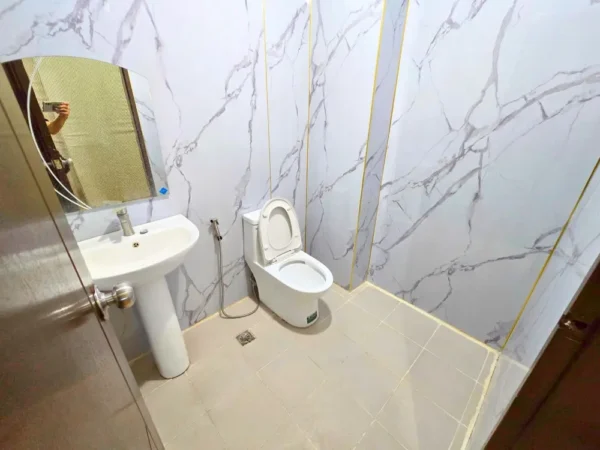 洗面台と鏡が設置されている5人部屋の共用トイレットルーム
