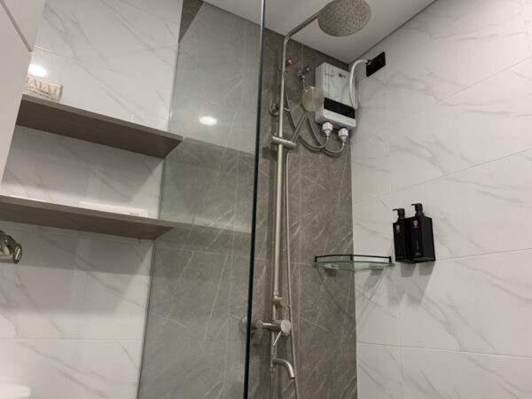 ヘッドシャワーとハンドシャワーが備わった電気温水器付きシャワーブース