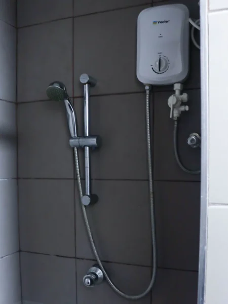 デラックストリプルルームのシャワーエリアにある電気温水器とシャワー