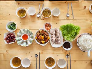アドボ、生春巻き、ポッサム、スープ、ブドウなどが並ぶ食卓