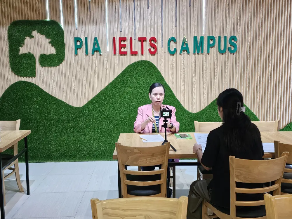 インタビュアーの前で学校を説明するジュナイダ主任教師