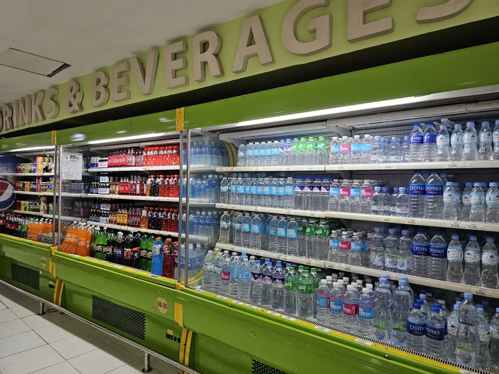 スーパーの冷蔵棚に並べられたペットボトル飲料水と様々なソフトドリンク