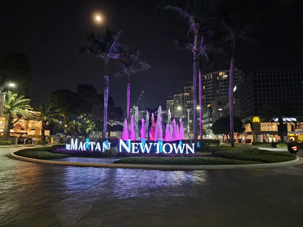 Mactan Newtownの入口にある噴水とヤシの木の夜景と月