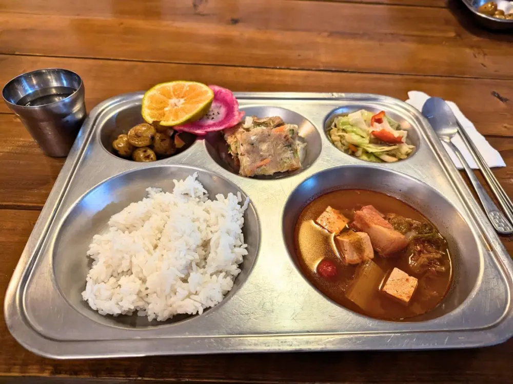 小玉ジャガイモ、チヂミ、野菜炒め、韓国風スープ、ドラゴンフルーツが盛り付けられた夕食