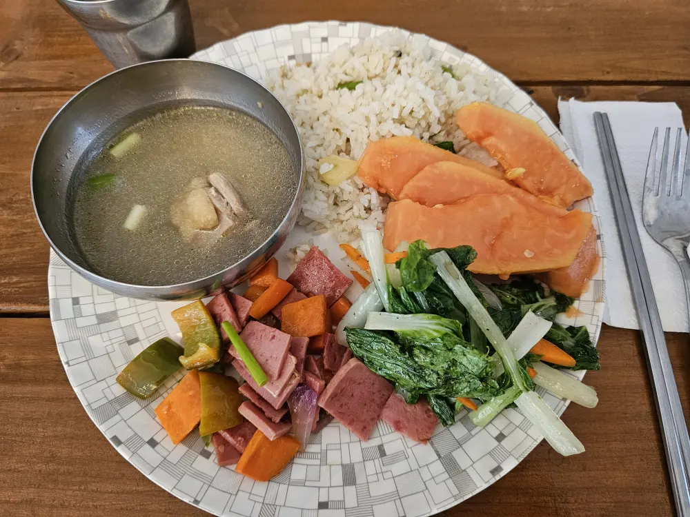 チキンスープ、ガーリックライス、野菜炒め、ハムソテーが盛り付けられた朝食プレート