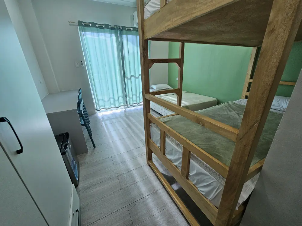 二段ベッド1台とシングルベッド1台が配置されたトリプルルーム