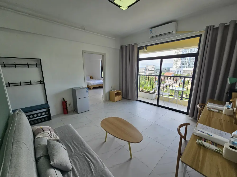 ソファと楕円形テーブル、2台の勉強机があるB’Cebuツインルームのリビング