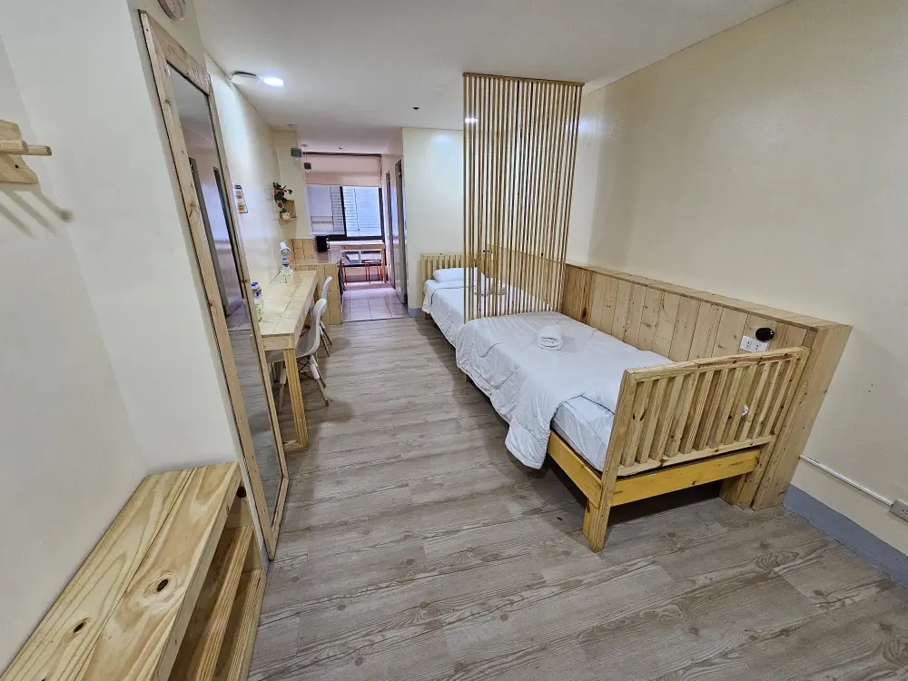 木の仕切りで区切られた2台のシングルベッドが並ぶツインルーム