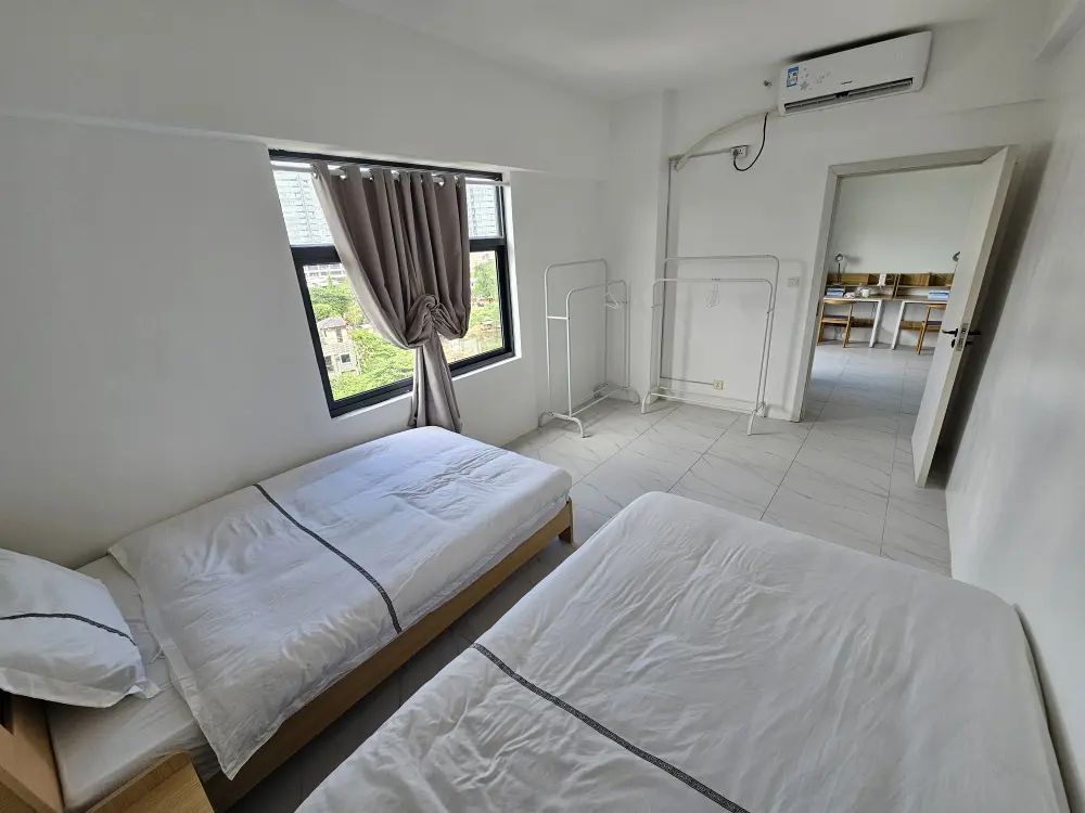 清潔な2台のベッドが並べて配置されたリビング付きツインルームの寝室