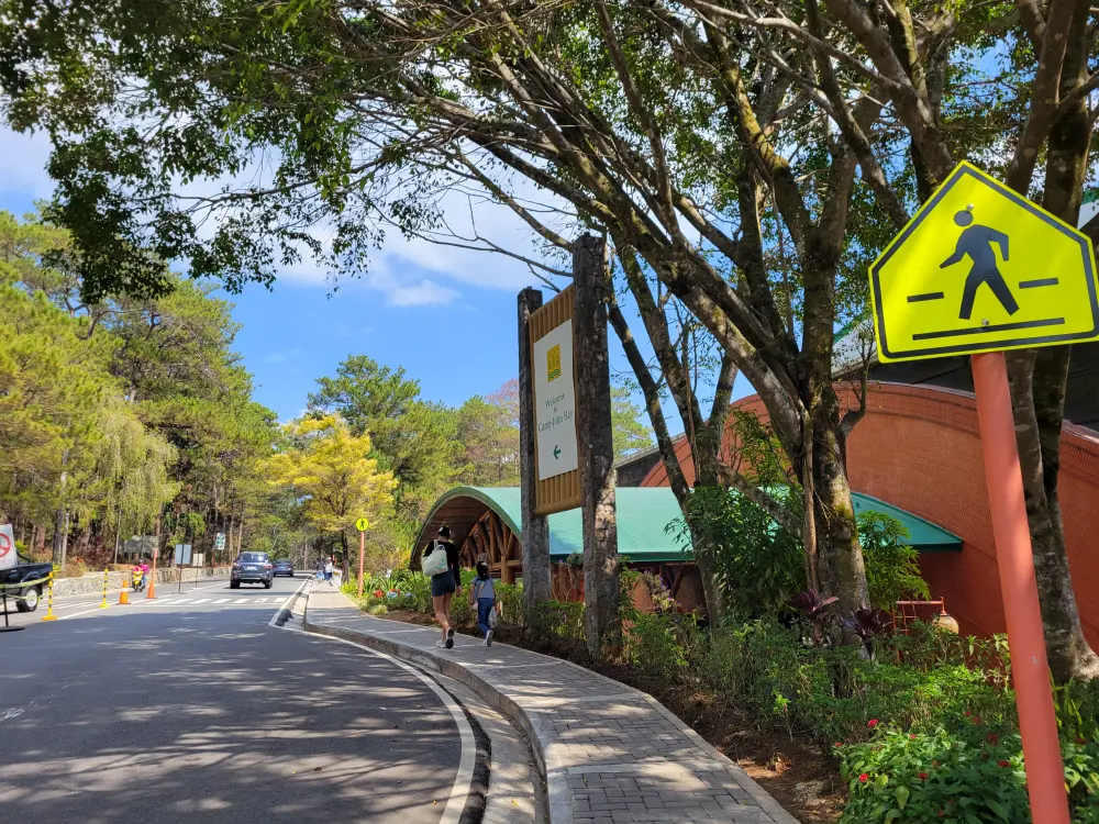 バギオのキャンプ・ジョン・ヘイのコンベンションセンター前を歩く女性と子ども