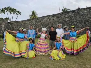 サン・ペドロ要塞の前でポーズをとるSinulog Festivalの衣装を着た男女とGrit留学の真太郎