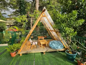 EOPキャンパスの外部寮のテラスにあるAフレーム型小屋とテーブル、キャンプチェア