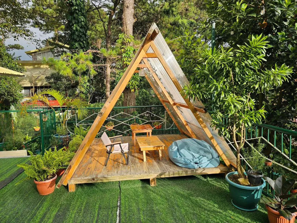 EOPキャンパスの外部寮のテラスにあるAフレーム型小屋とテーブル、キャンプチェア