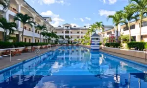 CPIの校庭の中央にある長さ50mのスイミングプールと周りの椰子の木