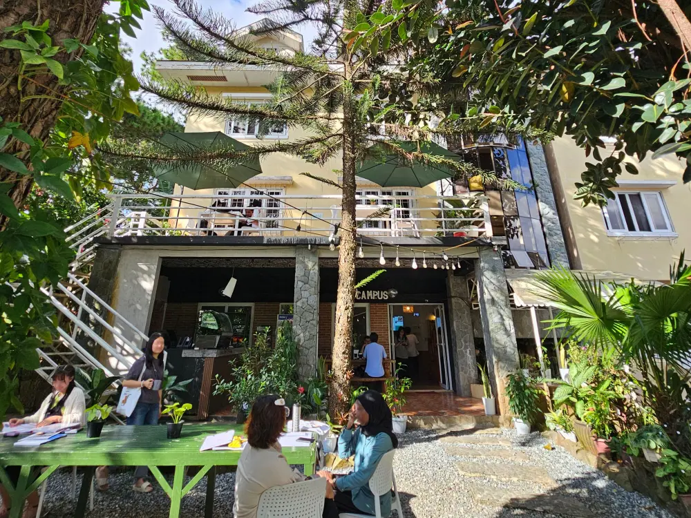 API BECI EOP Campusの緑に囲まれた庭でマンツーマン授業を行っている複数の講師と学生