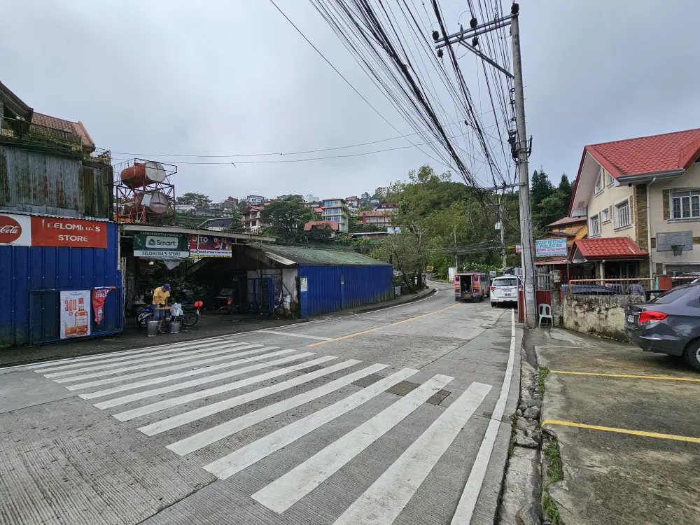 校舎正面の横断歩道と、向かい側にあるフィリピンのローカルレストラン