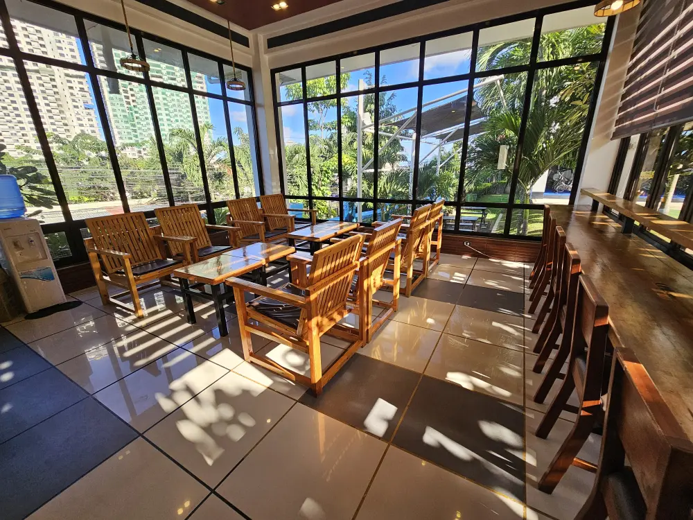 ガラス窓に囲まれ、木製のテーブルセットとカウンターのあるCPIの校内カフェ