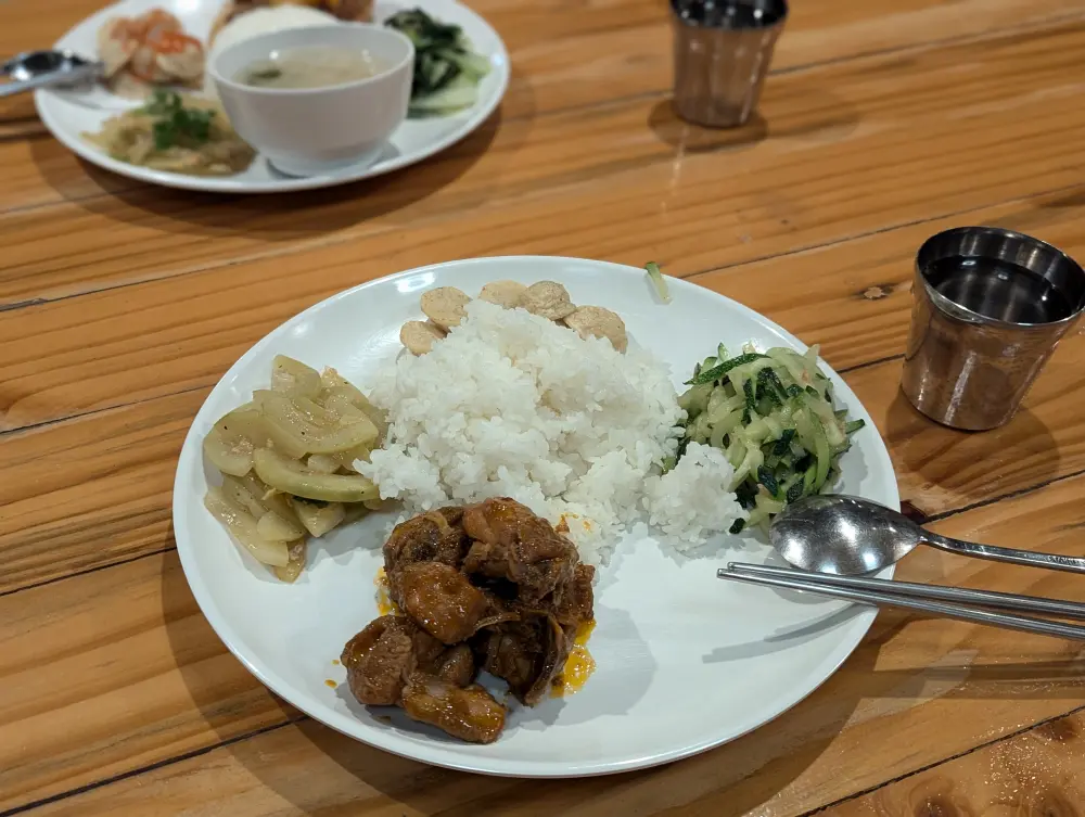 鶏肉の煮込み料理、ズッキーニとひょうたんの炒め物、フィッシュボール、白ご飯が盛られた夕食