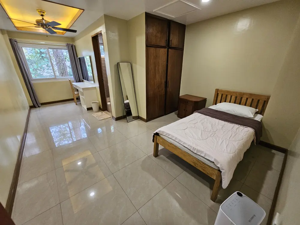 ベッド、クローゼット、除湿器、全身鏡、机が備わった、外部寮の女性用マスターシングルルーム