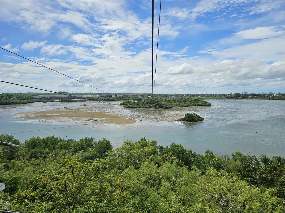 ジップラインのスタート台から見えるケーブル、リロアンの海、木々、岩場