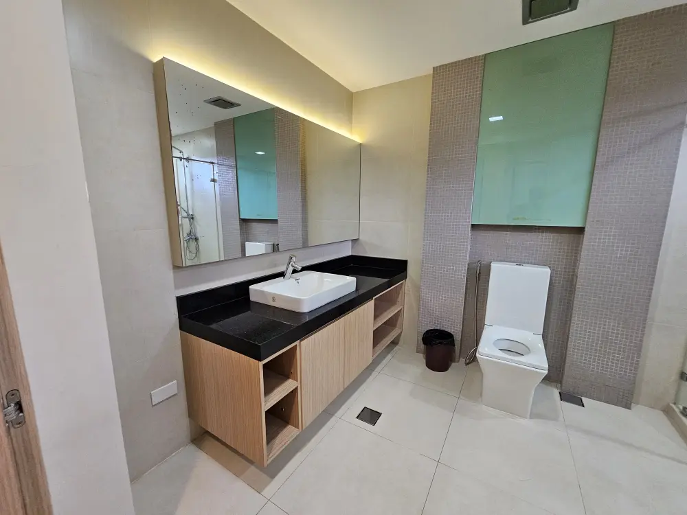 大きな洗面台カウンターと鏡、トイレが設置されたプレミアムスイートルームのバスルーム