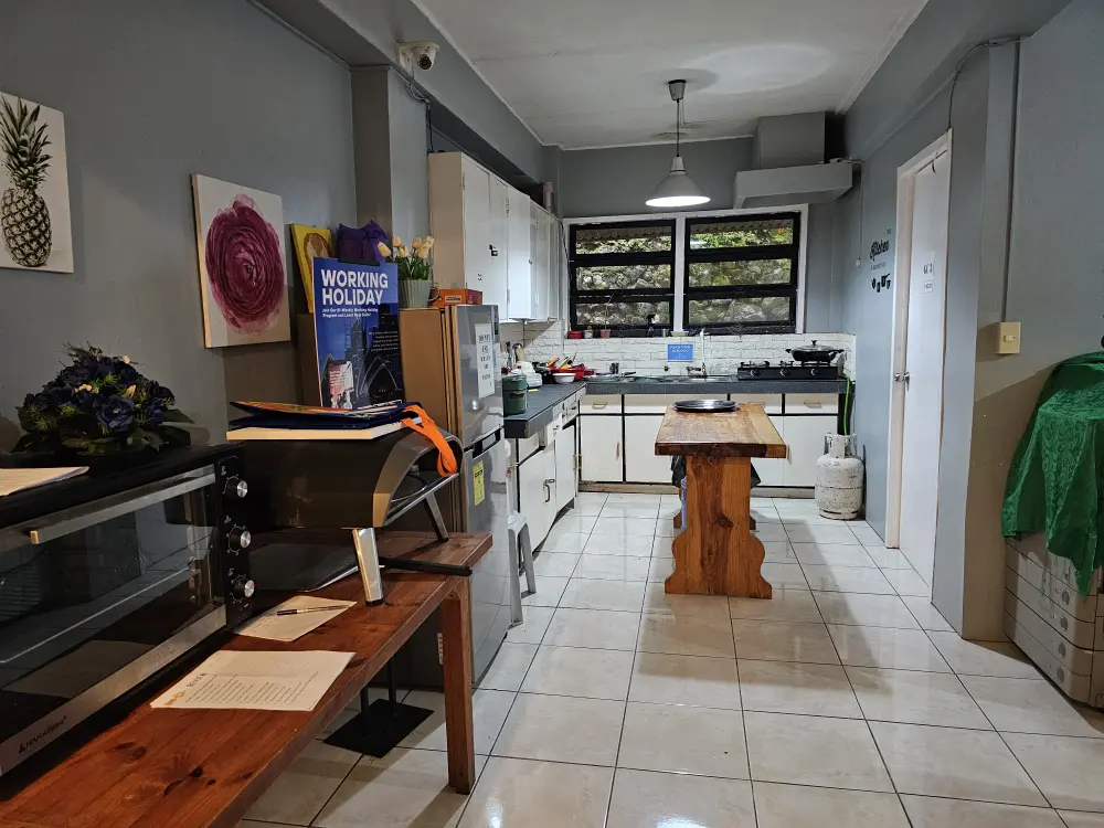 電子レンジ、ピザオーブン、冷蔵庫、シンク、調理器具、テーブルを備えたEOPキャンパスの共用キッチン