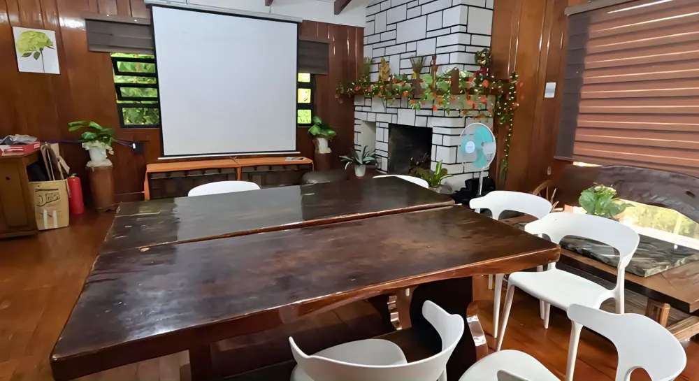 プロジェクタースクリーンがあり、大きな木製テーブルが置かれたEOPキャンパスの自習室