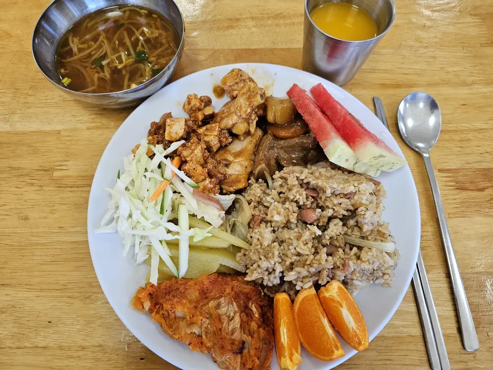 ポークアドボ、チキンカルデレータ、麻婆豆腐、野菜炒め、サラダ、チジミ、マンダリンの昼食