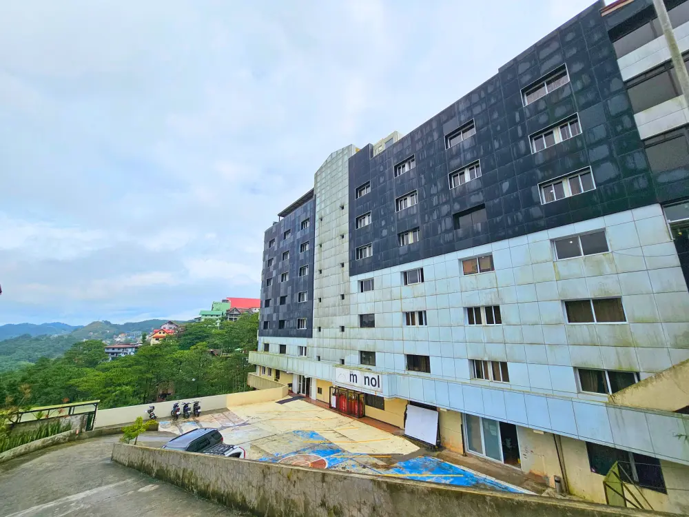 校舎前の道路から見たMONOLの建物外観と奥に広がる山々の景色