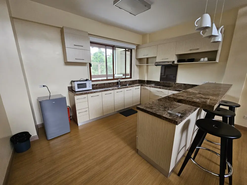 プレミアムユニットにある、冷蔵庫、電子レンジ、カウンターが備わったコの字型の共用キッチン