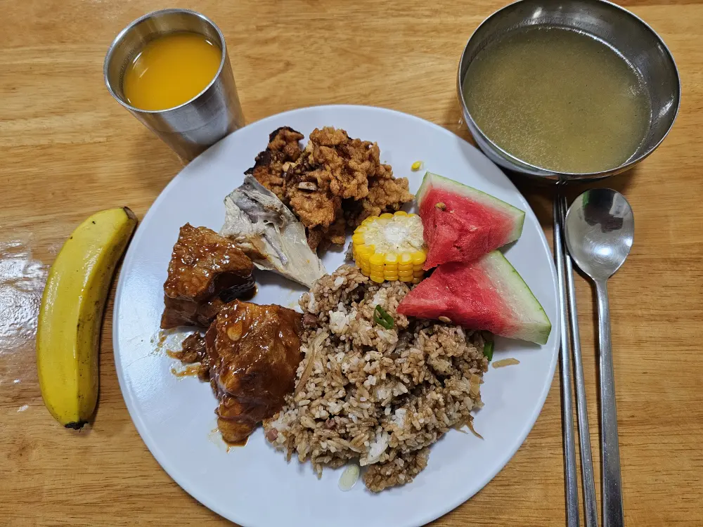 豚肉の煮物、ゆでチキン、油淋鶏風チキン、炒飯、トウモロコシ、スイカの夕食