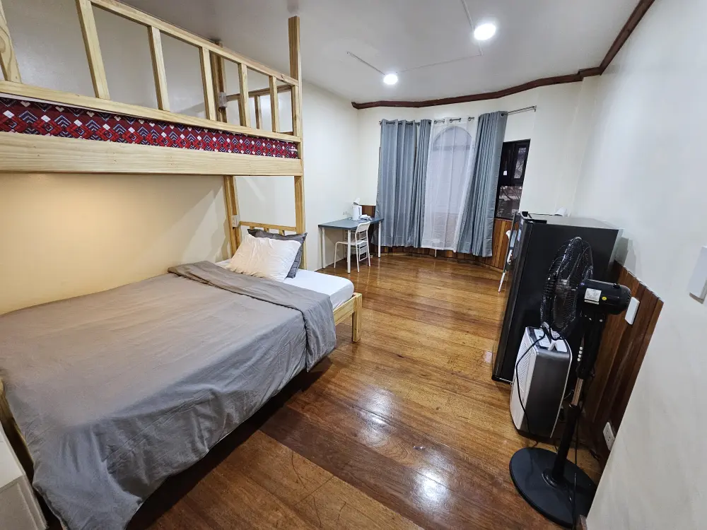 二段ベッド、加湿器、扇風機、冷蔵庫、机2台が備わったJIC Premiumのセミシングルルーム