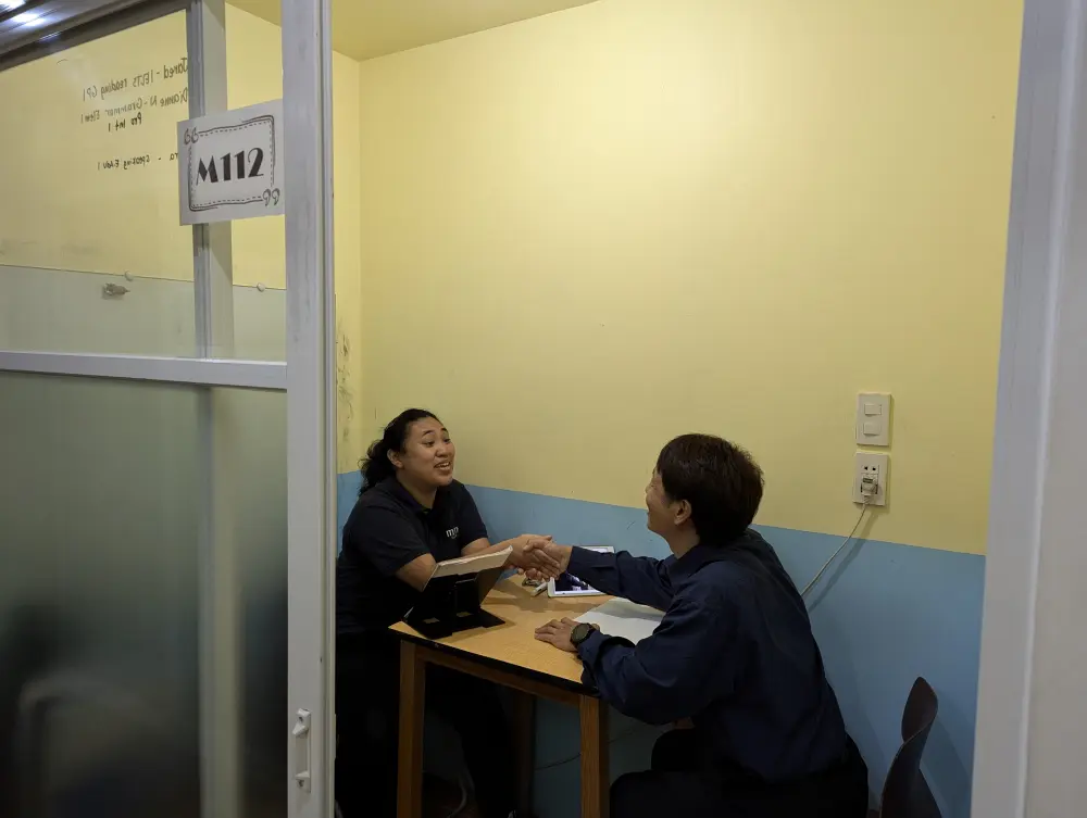 体験マンツーマンクラスの授業中に笑顔で握手を交わすCamille先生とGrit留学の真太郎