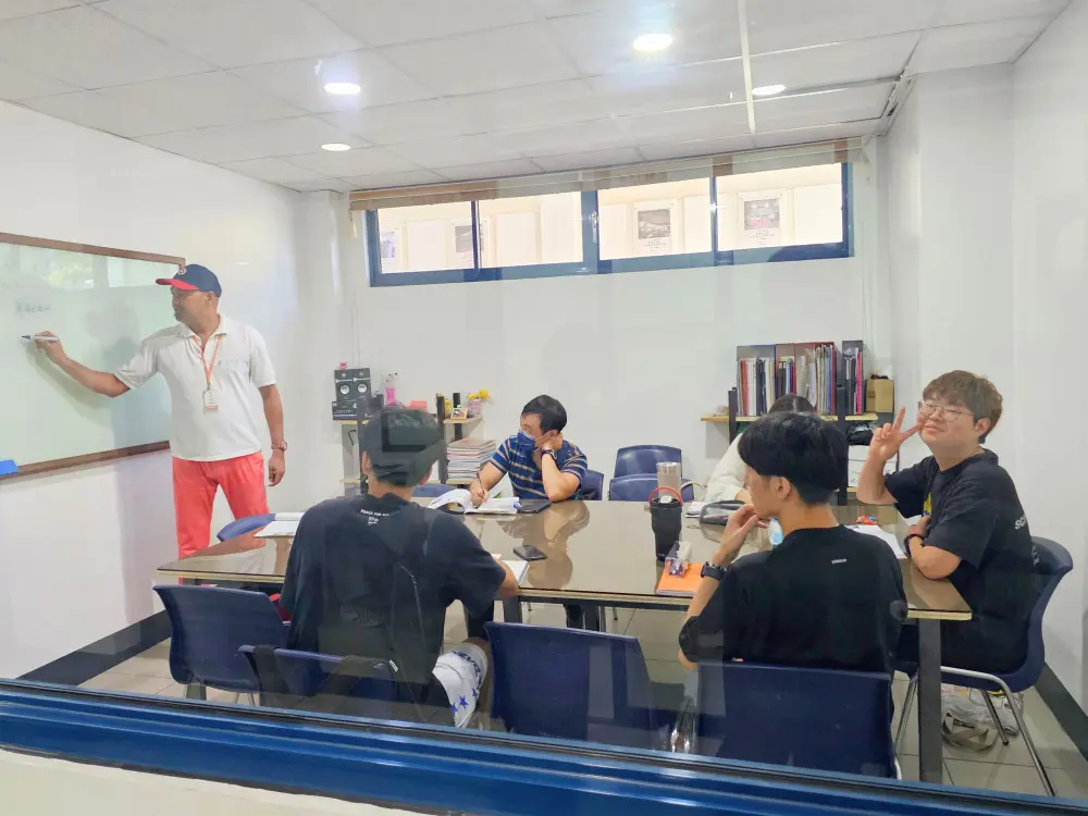 CPIのグループクラスで授業を行っている講師と説明を聞いている5人の学生