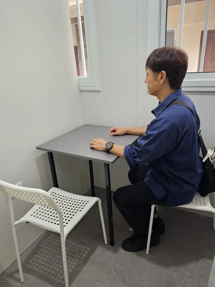 エコキャンパスのマンツーマンクラス用教室で椅子に座るGrit留学の代表