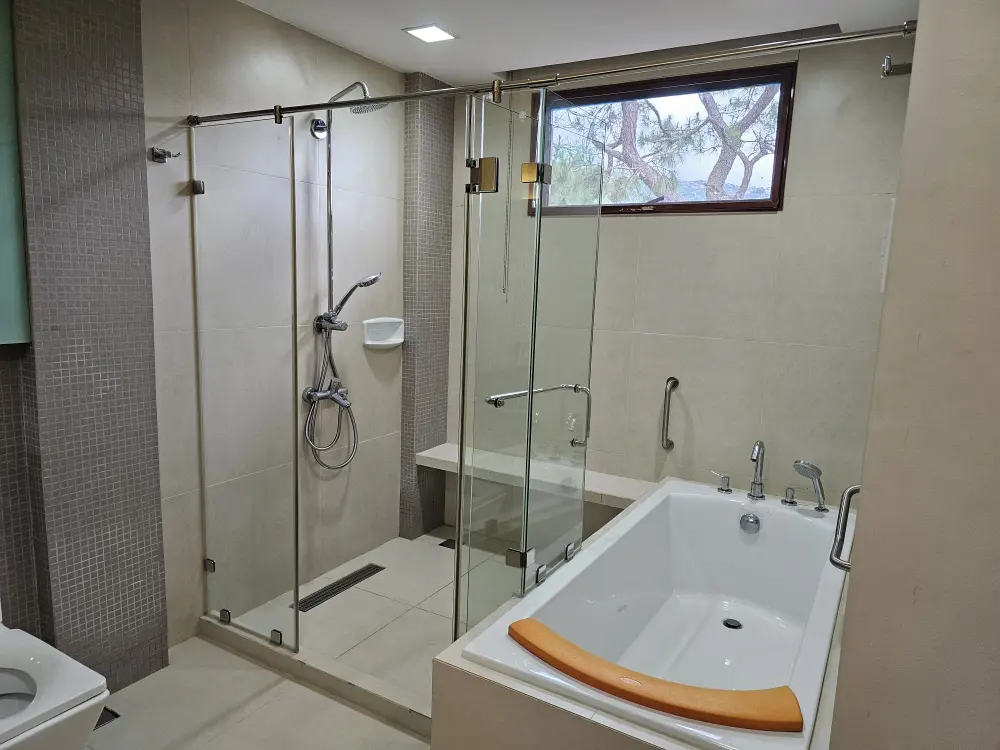 A&Jエコのプレミアムスイートに設置されたバスタブとガラス扉で仕切られたシャワーエリア