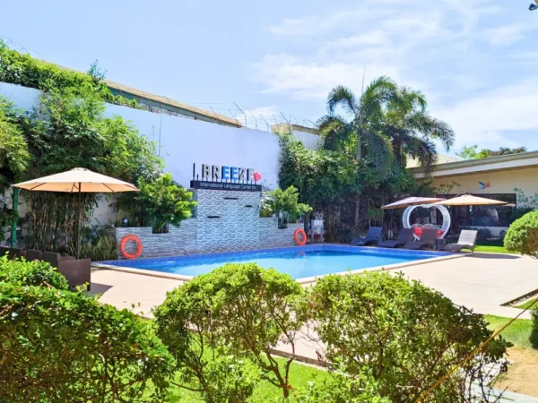 I.Breezeの敷地内にある庭に囲まれたスイミングプールとパラソル