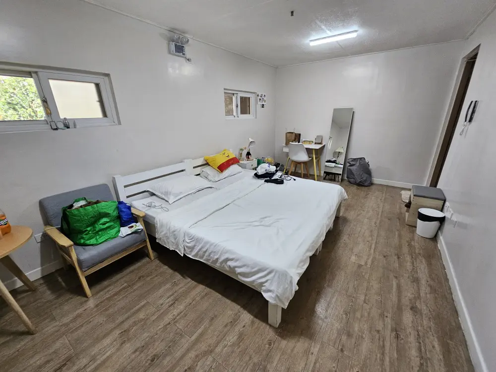 1人掛けソファー、大きなベッド、全身鏡、勉強机が備わったスタジオタイプシングルルーム