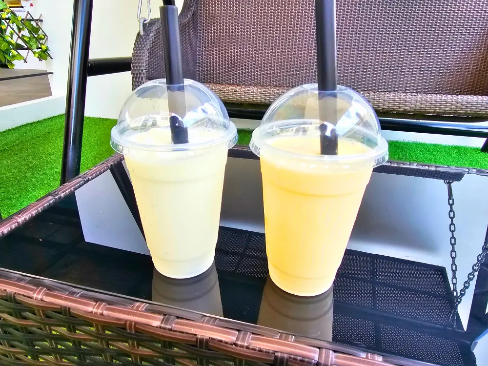 Breeze Caféのテーブルに置かれたプレーンヨーグルトスムージーとマンゴースムージー