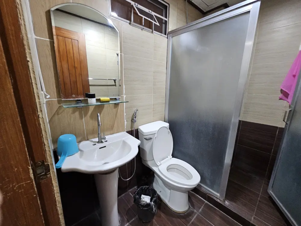 ガラスで仕切られたシャワーエリアとトイレ、洗面台が備わった4人部屋の共用バスルーム