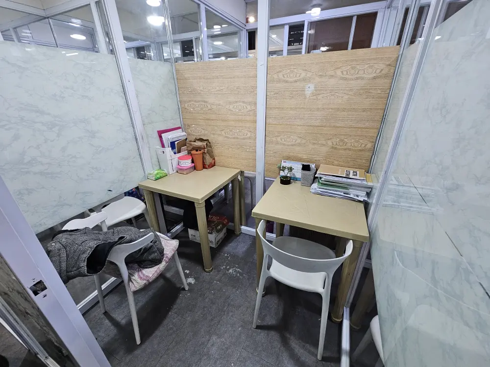 ガラス張りのマンツーマンクラス用教室に置かれた2組の机と椅子