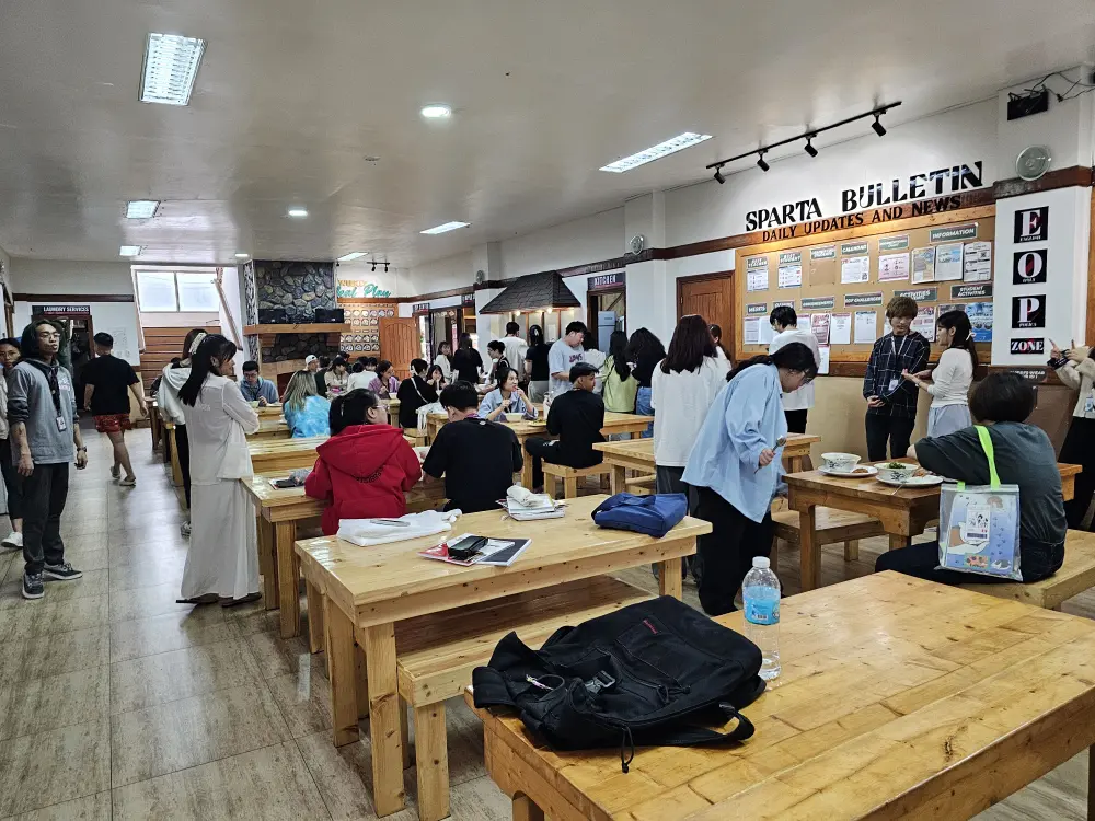 昼食時間にダイニングホールで食事をしているBECI Sparta Campusの学生たち