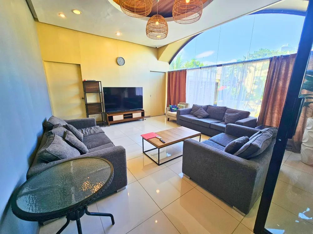 グレーの大きなソファと大型モニターを備えたIU English Academyのマルチメディアルーム