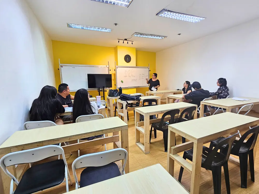 IU English Academyの大人数用教室でグループ授業を行う講師と受講している6人の学生