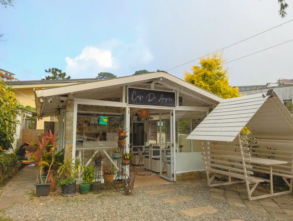 バギオのチャピスビレッジにあるCafé de Angeloの外観と、屋根付きの屋外テーブル席