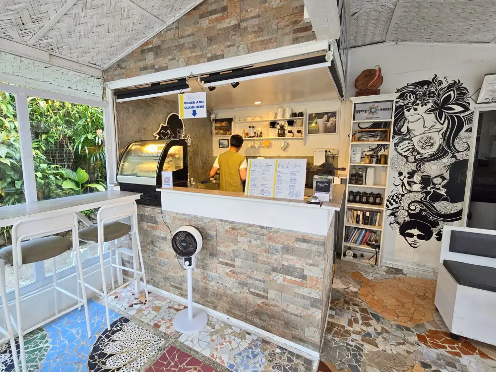 Café de Angeloの注文カウンターで作業するバリスタと窓際のハイカウンター席