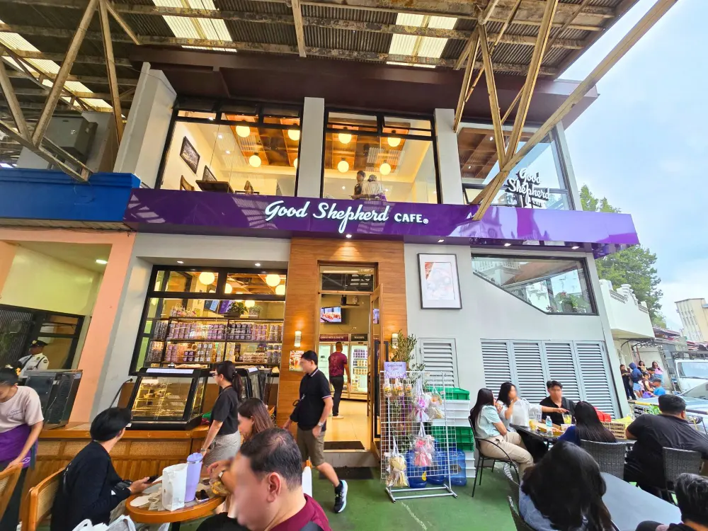 ウベを思わせる紫色の看板が目を引く、屋外席のあるGood Shepherd Caféの外観