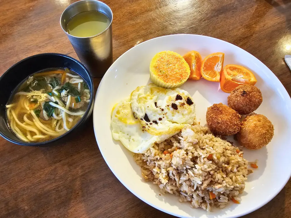 チャーハンや目玉焼き、コロッケ、卵料理、麺スープ、キアットキアットが並ぶICLの朝食