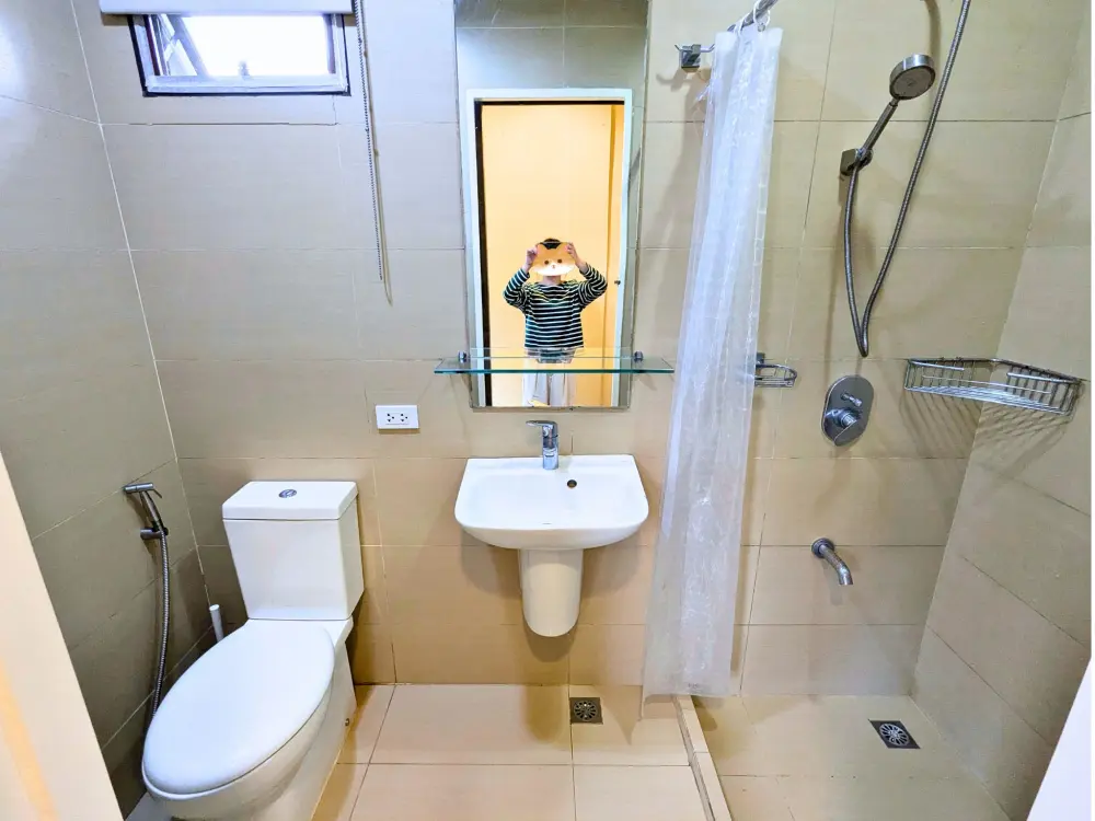 トイレとシャワーエリア、中央に洗面台を備えたECO Villaのバスルーム