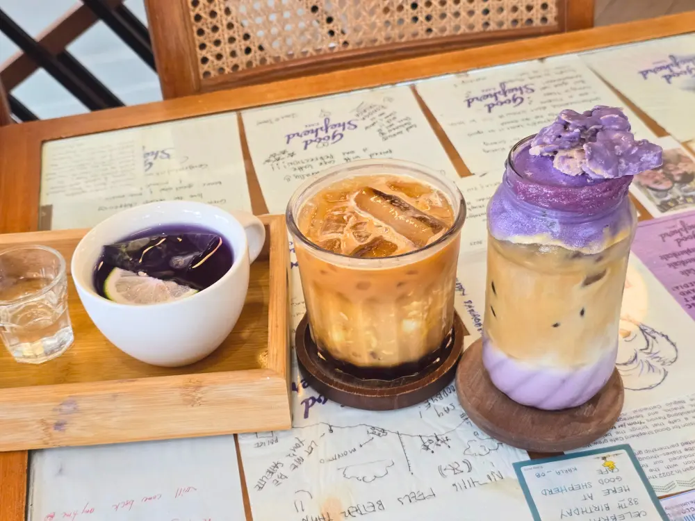 フィリピン・バギオにあるグッドシェパードカフェのテーブルに並ぶ、Butterfly Pea Tea、Taho Latte、Shepherd’s Latte